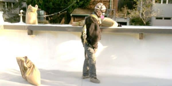 Armstrong Roofing - flat roof spf foam installation with an installer spraying the roof