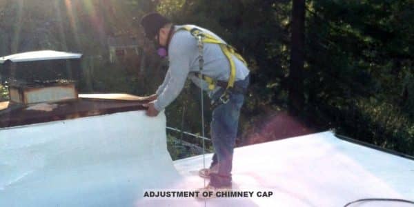 Armstrong Roofing - flat roof spf foam installation with an installer adjusting chimney cap
