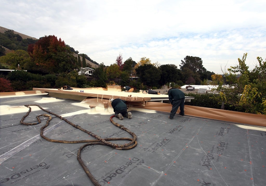 Armstrong Roofing - Two spf roofing installers prepare the roof for spraying