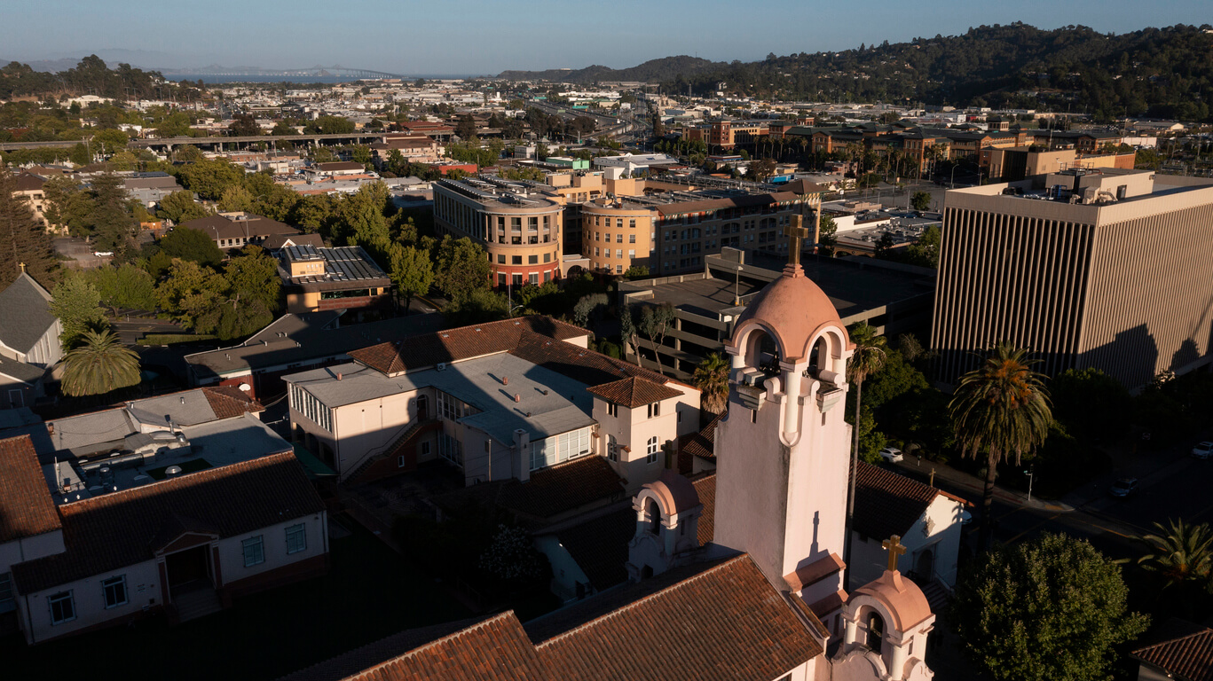 Sunset light shines on the historic Spanish Colonial mission and downtown skyline of San Rafael, California, USA.